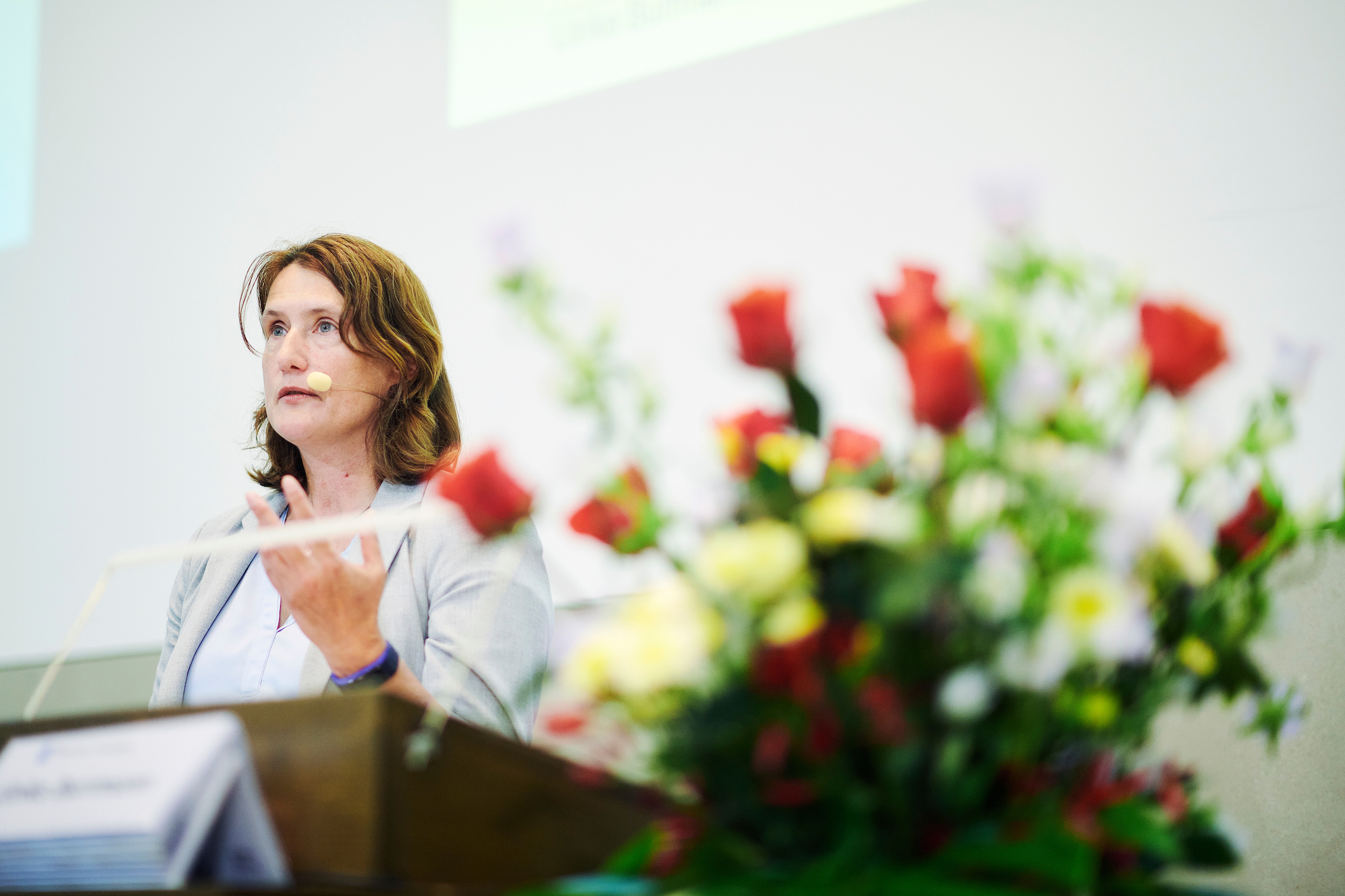 Die Referentin Ulrike Burrmann von der Humboldt-Universität zu Berlin während ihrem Referat an der Universität Bern. Neben ihr steht als Raumschmuck ein grosser Blumenstrauss