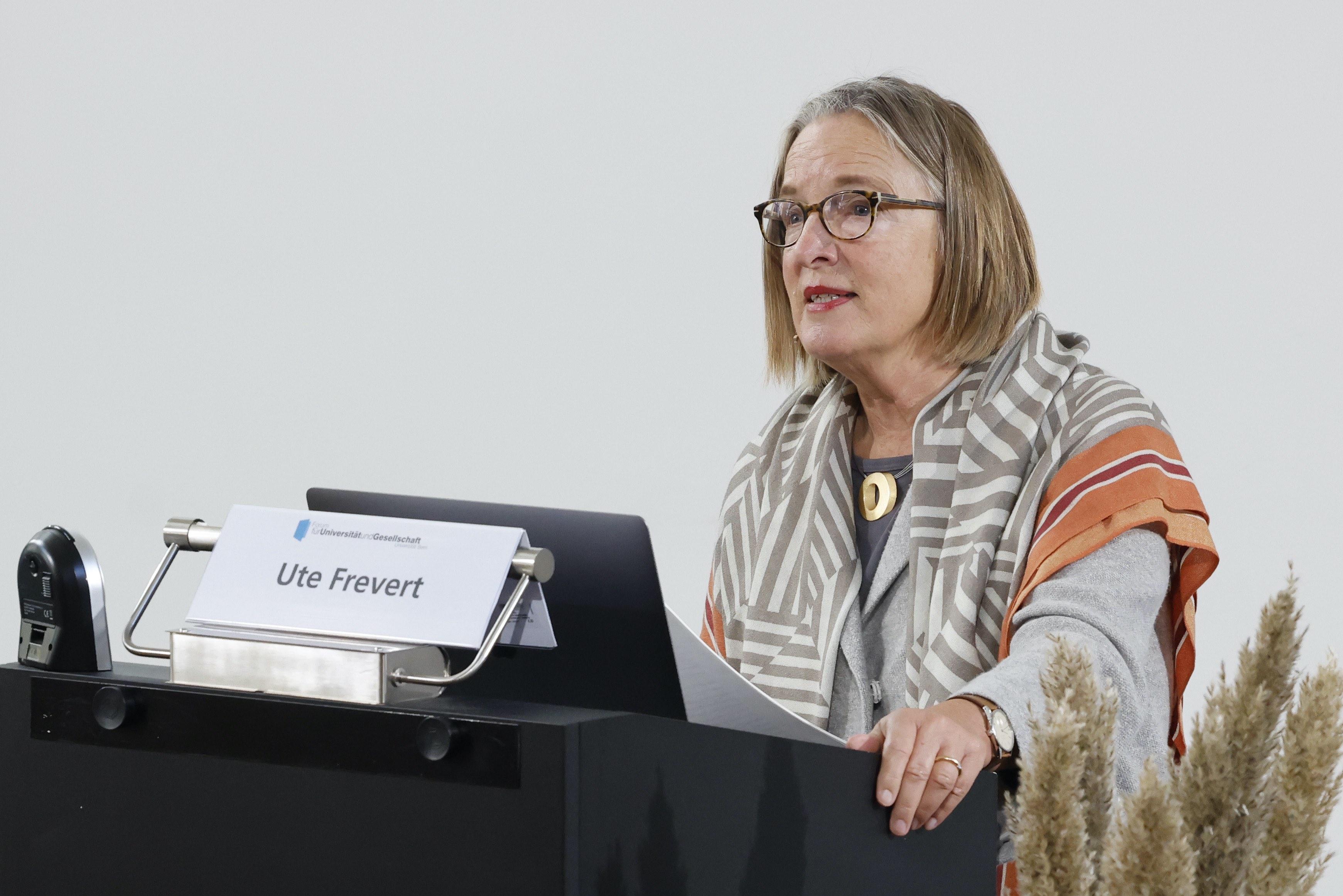 Die Referentin Prof. Dr. Ute Frevert vom Max-Planck-Institut für Bildungsforschung während ihrem Referat an der Universität Bern. Sie steht hinter einem Rednerpult mit einem Laptop.