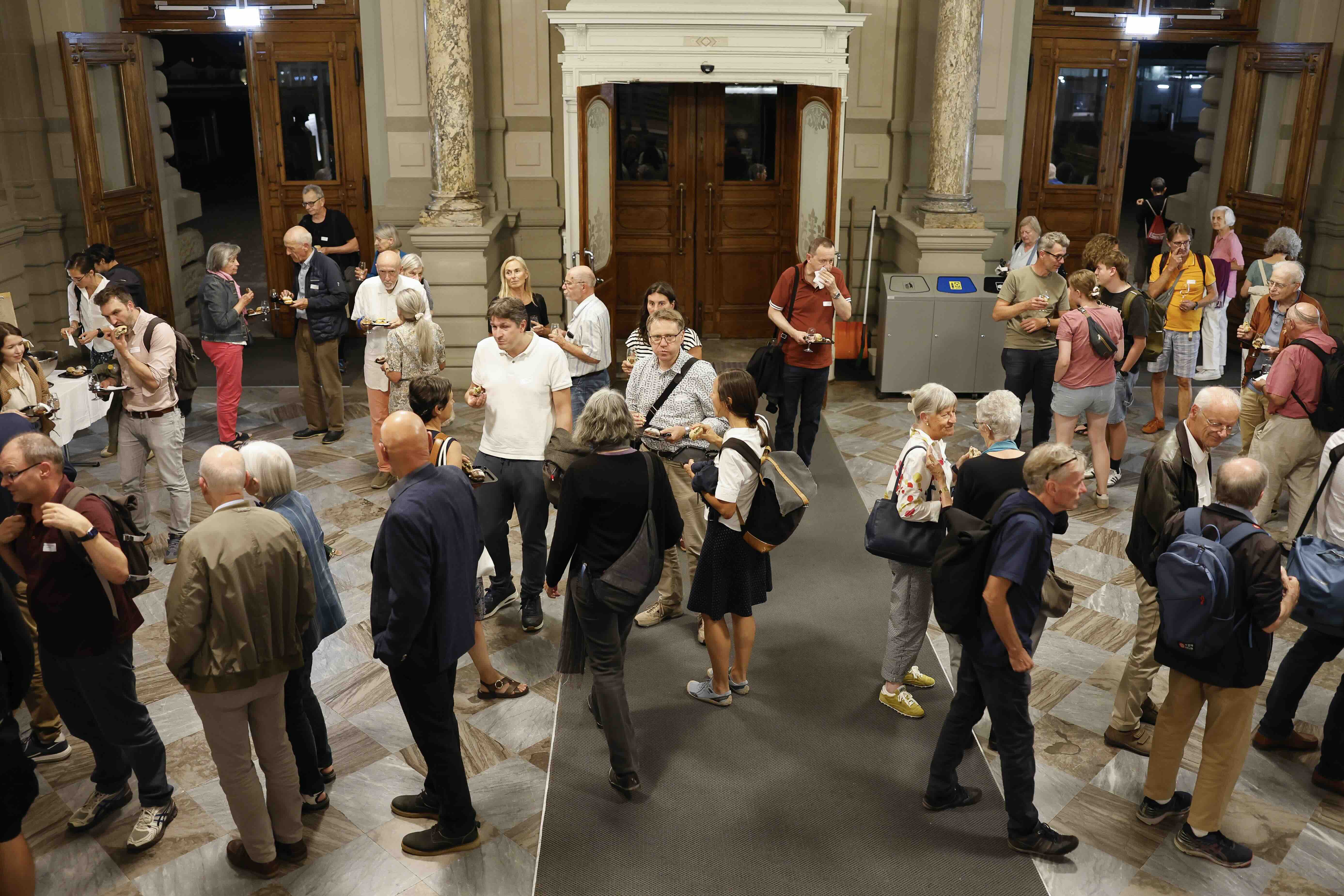 Teilnehmende beim Apéro in der Eingangshalle der Universität Bern.