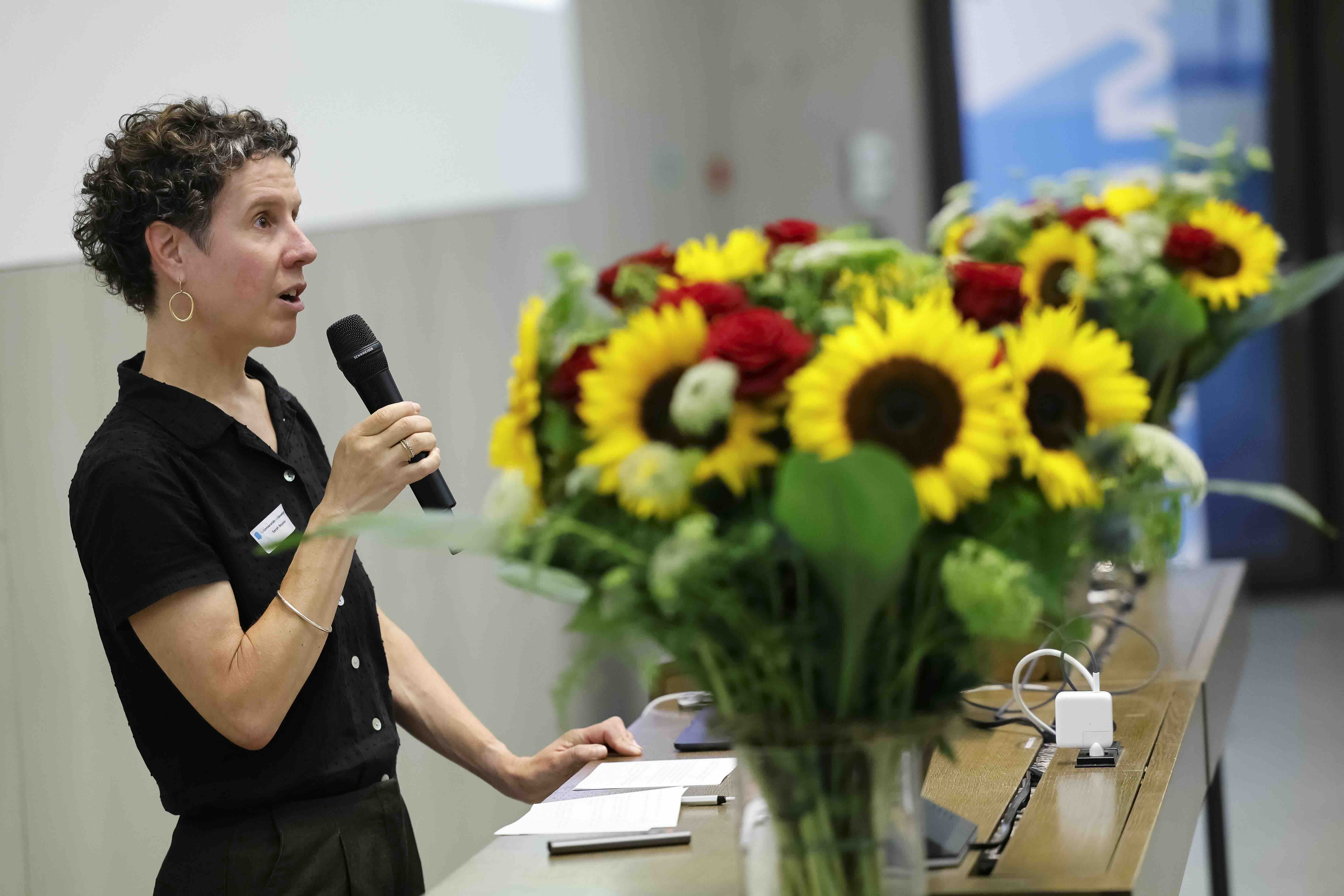 Sarah Beyeler steht am Rednerpult und begrüsst das Publikum zur Reihe über mentale Gesundheit.